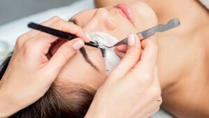 Profissional aplicando extensão de cílios premium com técnica avançada para acabamento natural, durabilidade e resultado de alta qualidade.